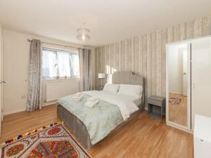 a bedroom with a bed with two towels on it at Spacious Home with Modern Amenities Near IKEA Pass the Keys in Reading