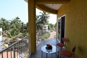 a room with a balcony with a table and chairs at Bedzzz Xclusiv Morjim, Goa By Leisure Hotels in Morjim