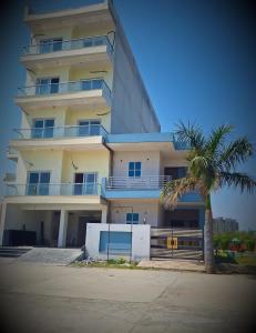 a large building with a palm tree in front of it at homeystay urbandream in Faridabad