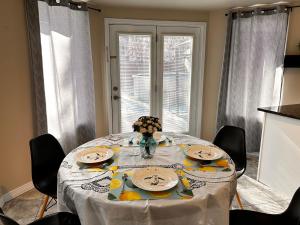 een eettafel met een wit tafelkleed en stoelen bij 多伦多湖畔别墅双人间1 in Bowmanville