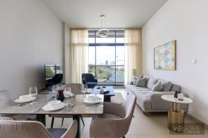 a living room with a table and a couch at WelHome - Prime 1BR Apartment at Oia Residence in Dubai