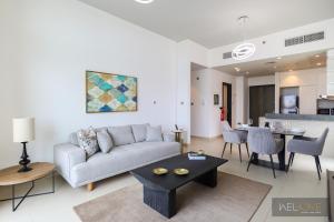 a living room with a couch and a table at WelHome - Prime 1BR Apartment at Oia Residence in Dubai