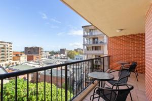 a balcony with two tables and chairs on a building at Spacious 3-Bed with Alfresco Dining by Amenities in Sydney