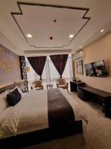 ドゥシャンベにあるFriendship HOTELの大型ベッドとテレビが備わるホテルルームです。