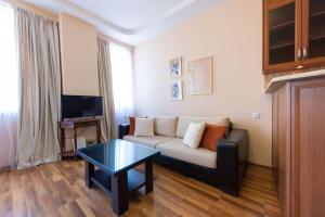 a living room with a couch and a table at GG Home - 1-Bedroom apartment in Saburtalo near metro in Tbilisi City