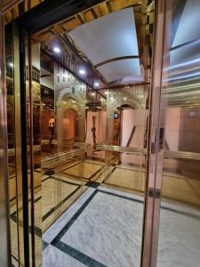 um quarto com uma porta de vidro e um corredor em Friendship HOTEL em Dushanbe