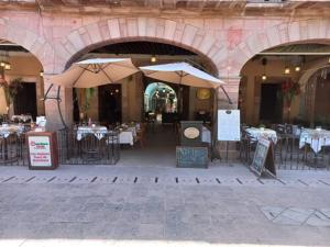 um restaurante com mesas e guarda-sóis num edifício em Hotel Plaza D Armas em Querétaro