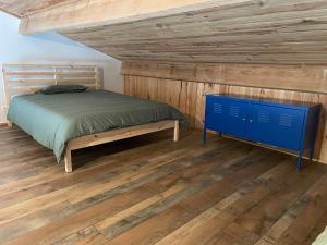 sypialnia z łóżkiem i drewnianym sufitem w obiekcie l'Héberge du Lac d'Isachris (Médoc) w mieście Queyrac