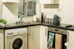 a kitchen with a sink and a washing machine at Cosy and Modern 2 Bedroom Home in Faulkner St., Chester in Chester