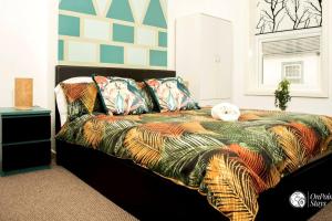 a bedroom with a bed with colorful blankets and pillows at Cosy and Modern 2 Bedroom Home in Faulkner St., Chester in Chester