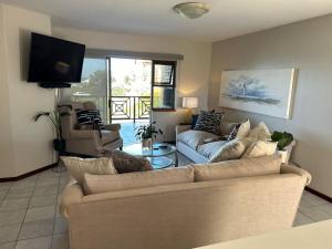 a living room with a couch and a tv at Beacon Point in Mossel Bay