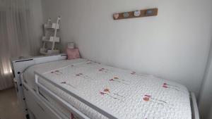 a bedroom with a bed with white sheets and flowers on it at Tahona in Carmona