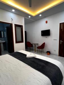 een slaapkamer met een bed en een tafel met stoelen bij Hotel Trending Stay in New Delhi