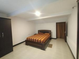 ein Schlafzimmer mit einem Bett in der Zimmerecke in der Unterkunft Beauty and the Beast in Diyatalawa