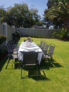 a table with chairs and a white table cloth on a lawn at Nid de Rêve Accomodation in Sandton +5 photos