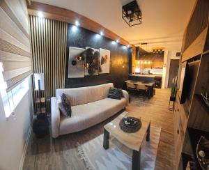 ein Wohnzimmer mit einem Sofa und einem Tisch in der Unterkunft Apartman Lena in Zrenjanin