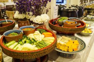 un buffet avec des bols de différents types de légumes dans l'établissement At Pingnakorn Hotel, à Chiang Mai