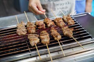 a group of skewers of food cooking on a grill at At Pingnakorn Hotel in Chiang Mai