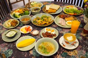 uma mesa coberta com pratos de alimentos e bebidas em At Pingnakorn Hotel em Chiang Mai