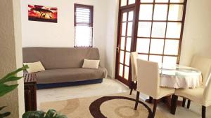 ein Wohnzimmer mit einem Sofa und einem Glastisch in der Unterkunft Apartments Happy Day in Karlobag