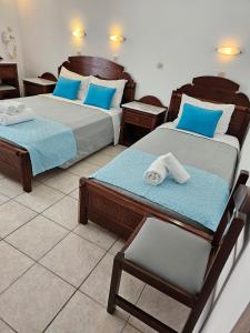 pokój z 2 łóżkami i krzesłem w obiekcie Hotel Leta w Firze