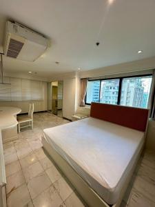 ein Schlafzimmer mit einem großen weißen Bett in einem Zimmer in der Unterkunft UrbanZen Suite in Bangkok