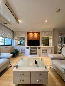 ein Wohnzimmer mit einem Sofa und einem Tisch in der Unterkunft UrbanZen Suite in Bangkok