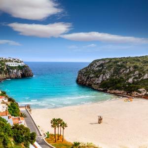 una playa con palmeras y el océano en New familiar lovely apartment in Cala en Porter, en Cala'n Porter