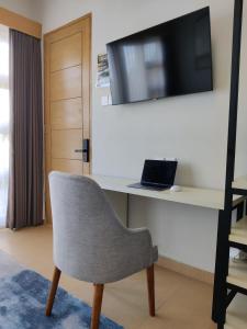 a room with a chair and a tv on a wall at SUNNYRENT. Guest villa Dreamland in Ungasan