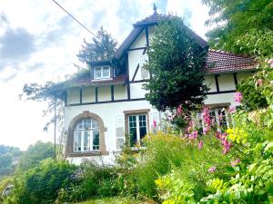 a white house with flowers in front of it at LA VILLA DES OISEAUX - La Petite Pierre in La Petite-Pierre