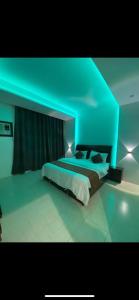 a room with a bed with a blue ceiling at الديوان النجدي للشقق المخدومة in Ukaz