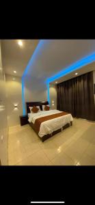 um quarto com uma cama com luzes azuis em الديوان النجدي للشقق المخدومة em Ukaz
