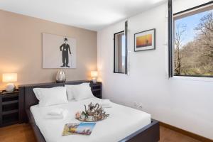 Schlafzimmer mit einem Bett und einem Fenster in der Unterkunft Villa Dolce Vita With Private Pool - Happy Rentals in Lugano