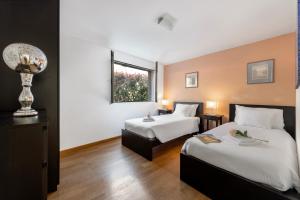 a hotel room with two beds and a window at Villa Dolce Vita With Private Pool - Happy Rentals in Lugano