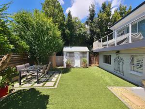 a backyard with a table and chairs and a house at 10 on Gillian Self-catering Apartments - NOT AFFECTED BY LOADSHEDDING in Eversdal