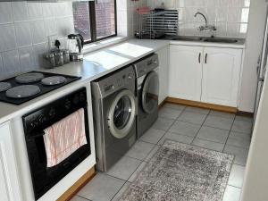 a kitchen with a stove and a washing machine at Beacon Point in Mossel Bay +9 photos