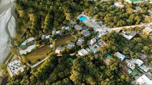 an aerial view of a group of houses and trees at voco Jim Corbett, an IHG Hotel in Rāmnagar