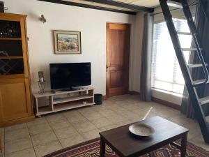 a living room with a television and a table at BLessing at Lynnwood in Pretoria