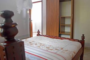 una camera da letto con letto con struttura in legno e specchio di Serene Homes a Jinja