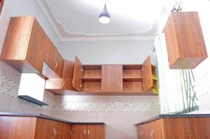 una cucina con armadi in legno e soffitto di Serene Homes a Jinja