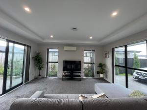 a living room with a couch and a tv at Luxury 4 Bedroom Family Retreat in Lincoln