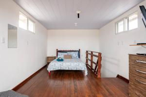 ein Schlafzimmer mit einem Bett in einem Zimmer mit weißen Wänden in der Unterkunft Flat Romântico da Guarda do Embaú SC in Palhoça