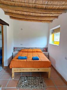 una camera da letto con un letto con cuscini blu di El Sueñerito a Tilcara