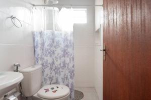 ein Badezimmer mit Toilette und Duschvorhang in der Unterkunft Flat Romântico da Guarda do Embaú SC in Palhoça + 36 Fotos