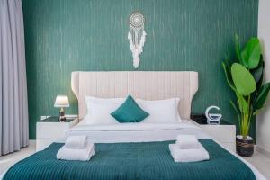 a bedroom with a large bed with a green wall at Specious pool view One Bed room in Dubai