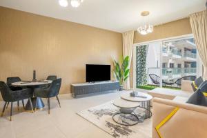a living room with a couch and a tv at Specious pool view One Bed room in Dubai