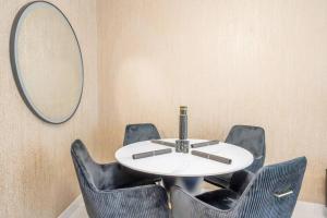 a round table with black chairs and a mirror at Specious pool view One Bed room in Dubai