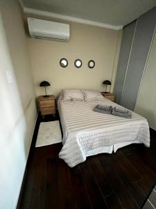 a bedroom with a large bed and two mirrors at BE ONE III IRIGOYEN - EXCELENTE DEPARTAMENTO A ESTRENAR MODERNO, UBICADO EN EL CORAZON DEL CAMBA CUA in Corrientes
