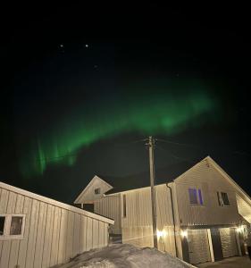 uma imagem das luzes do norte no céu em Leilighet ved porten til Senja. em Finnsnes