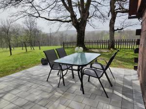 einen Tisch und vier Stühle auf einer Terrasse in der Unterkunft Peace Creek in Slunj